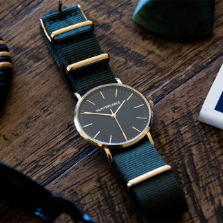 Black dress watch on a table.